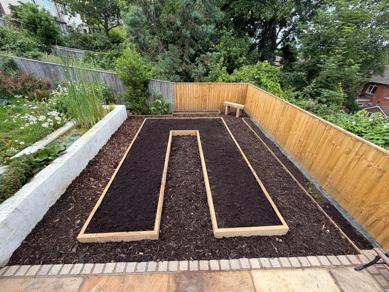 Finished raised beds edged in oak, freshly filled with topsoil